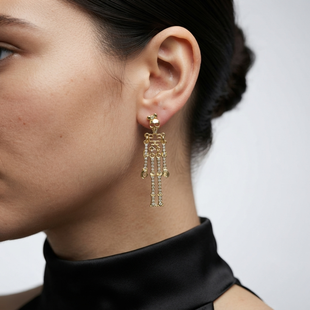 A close-up side profile of a woman wearing a delicate gold skeleton-shaped dangle earring with small clear stones, paired with a black satin high-neck top against a light gray background by Civaro