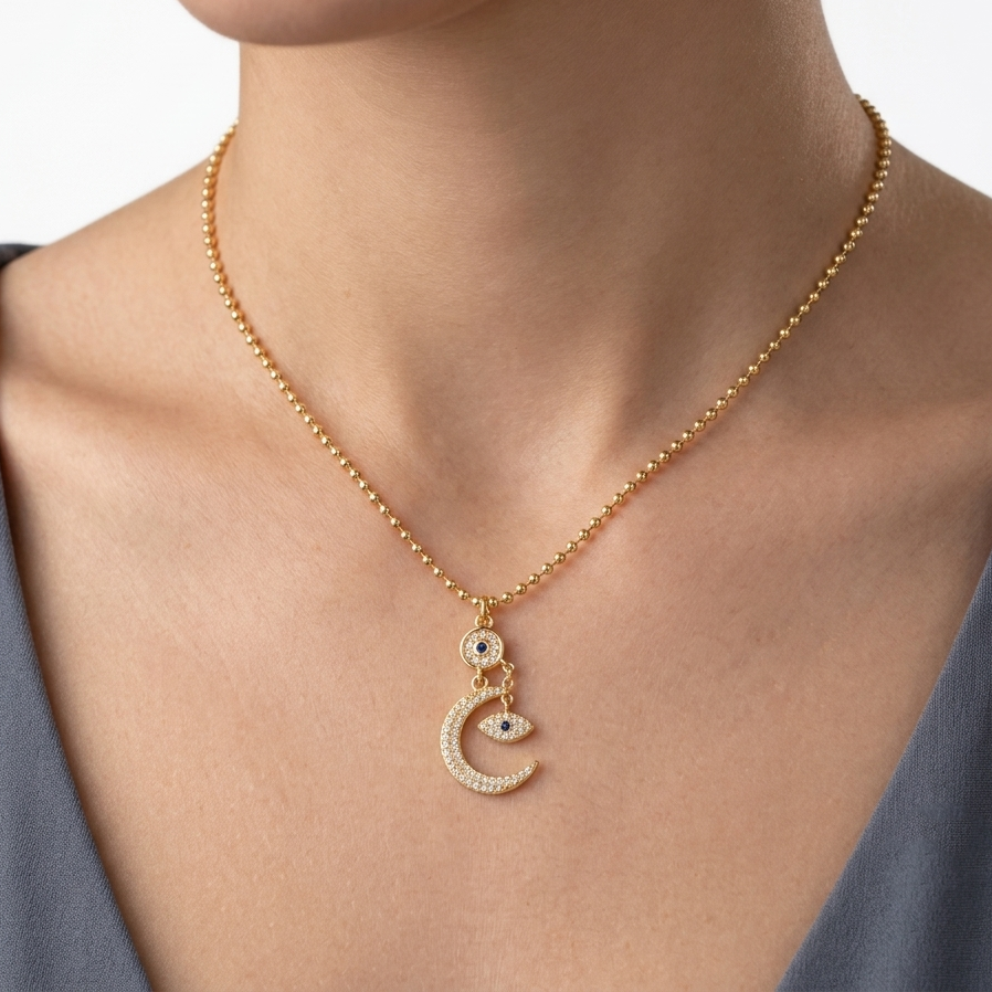 Celestial crescent moon necklace featuring sparkling CZ evil eye charm.
