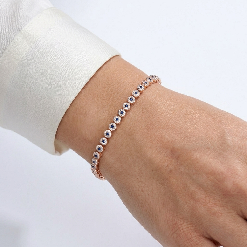 Close up of model hand wearing blue and white stone tennis bracelet