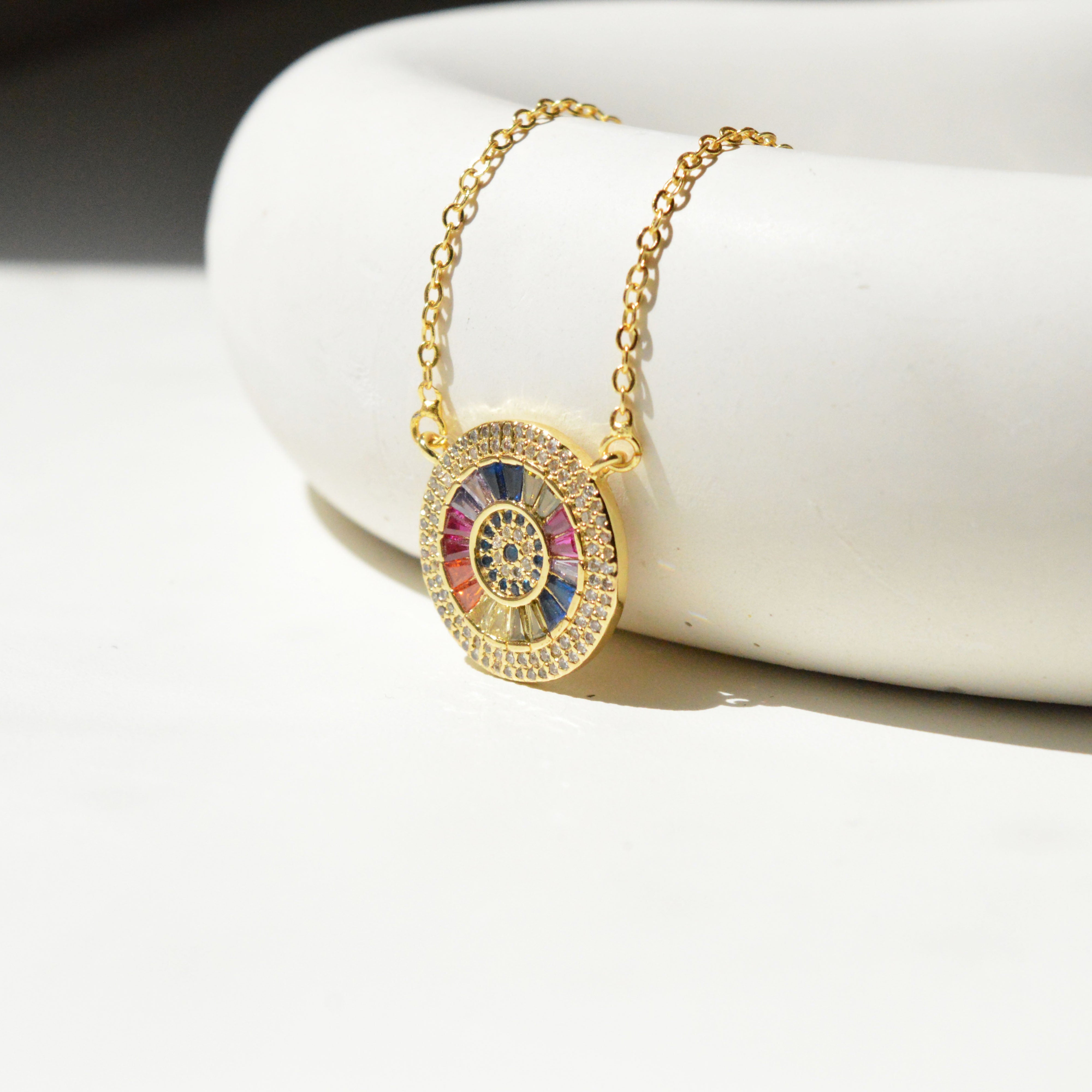 Close up of the concentric rings, channel-set baguette stones, and micro-pavé borders on the anti-tarnish Iris Medallion