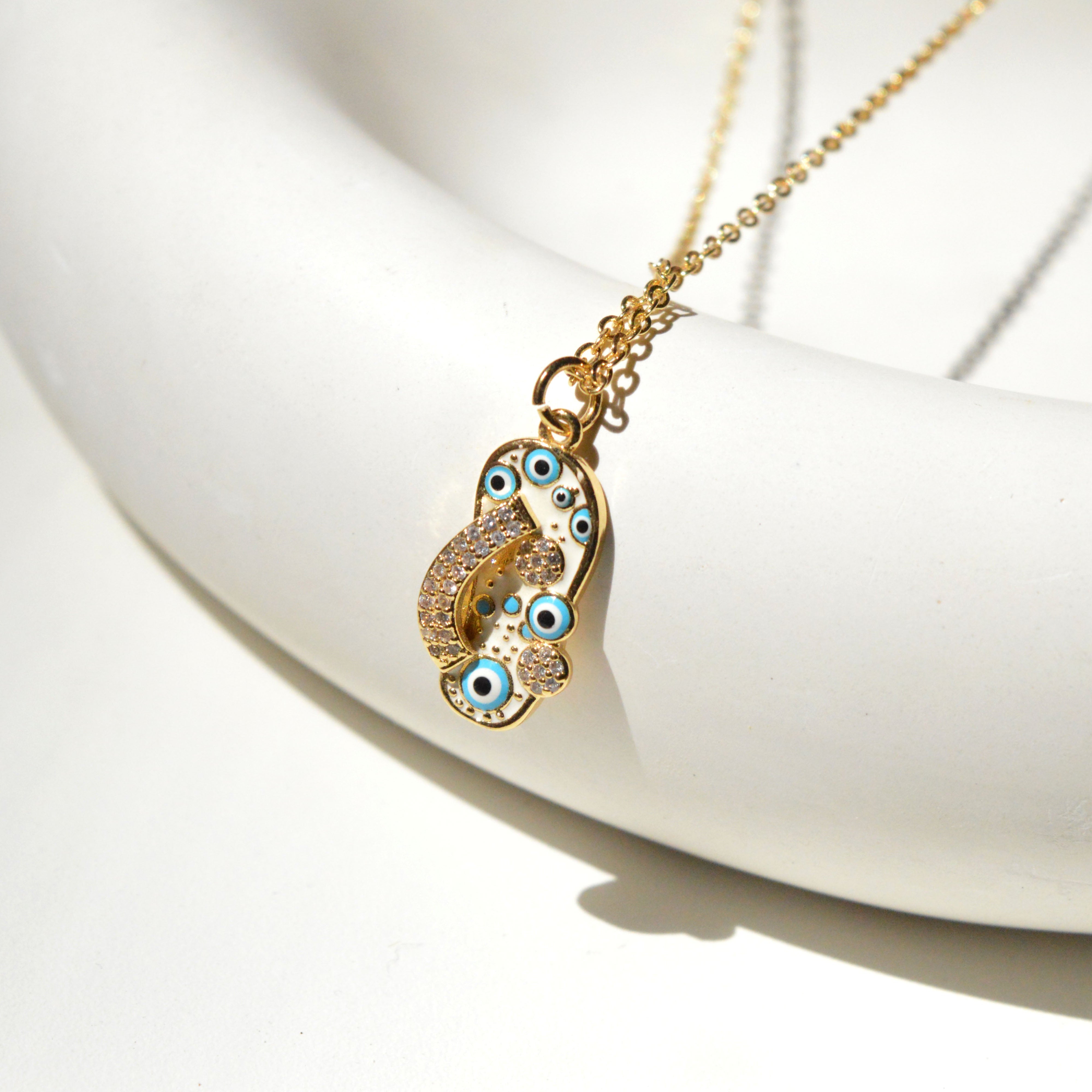 Side angle of The Amulet pendant highlighting the clean stainless steel frame and vibrant color detailing