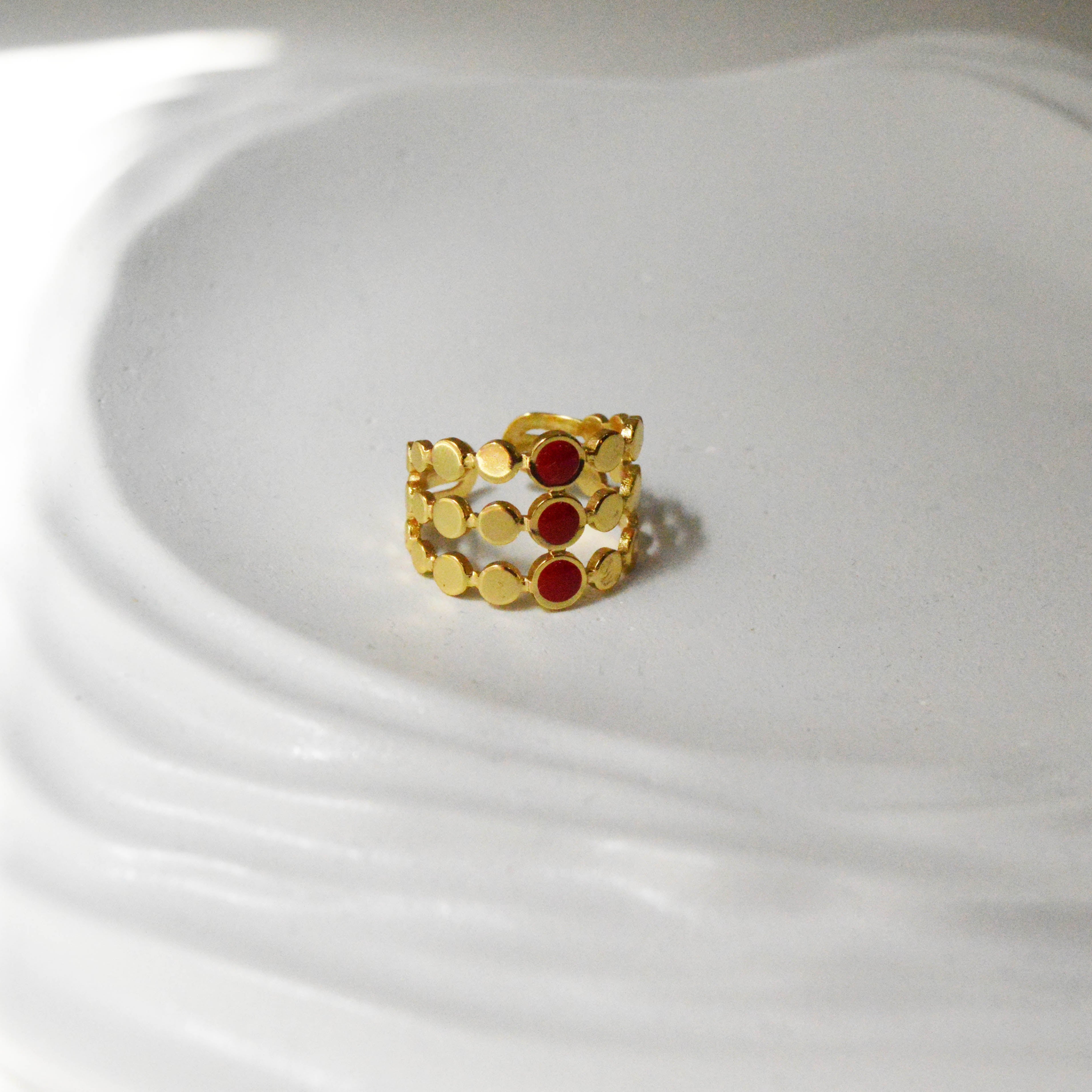 The anti-tarnish gold-toned Crimson Signet ring highlighting its open cage architecture and red enamel inlay