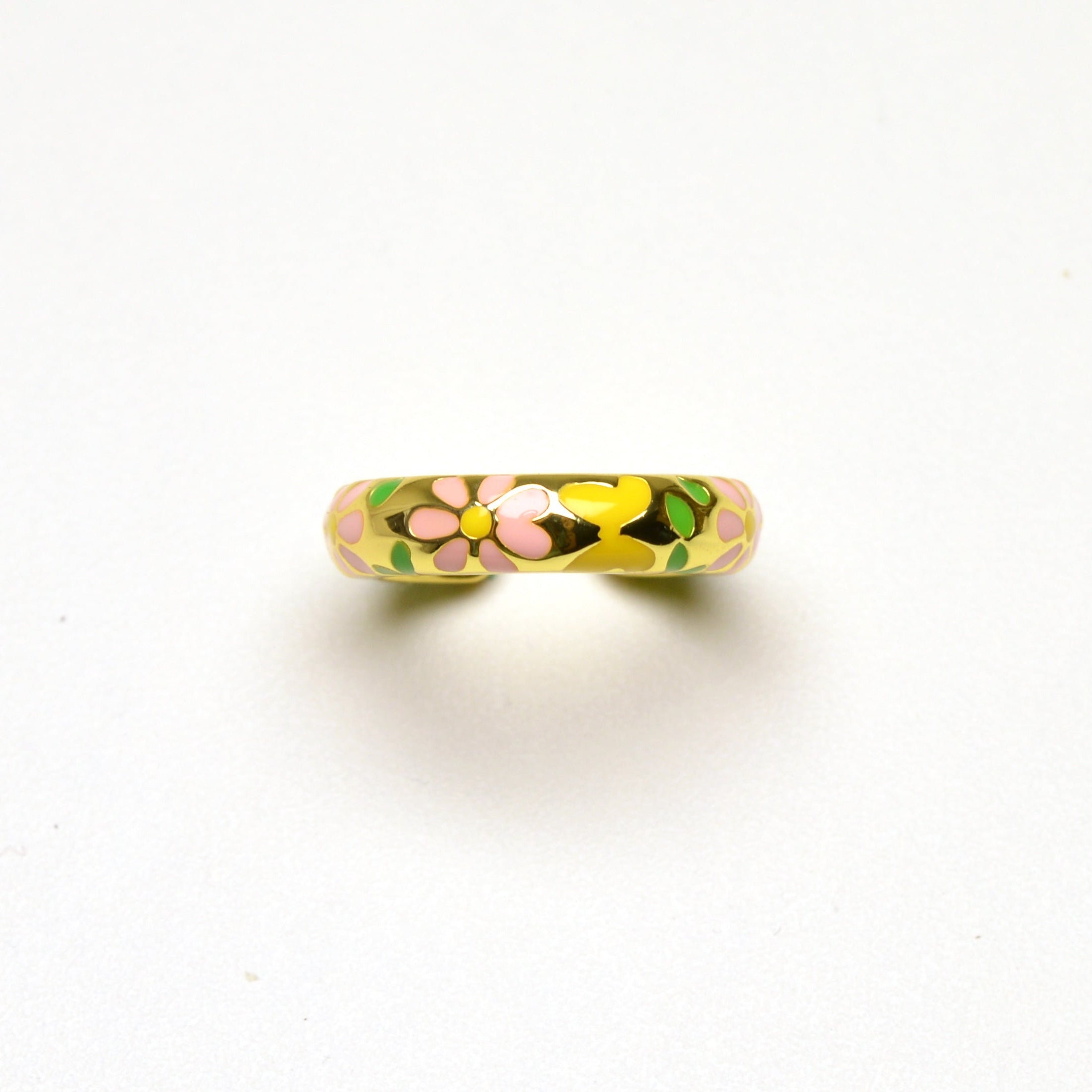 Close-up of daisy enamel ring with gold tone finish