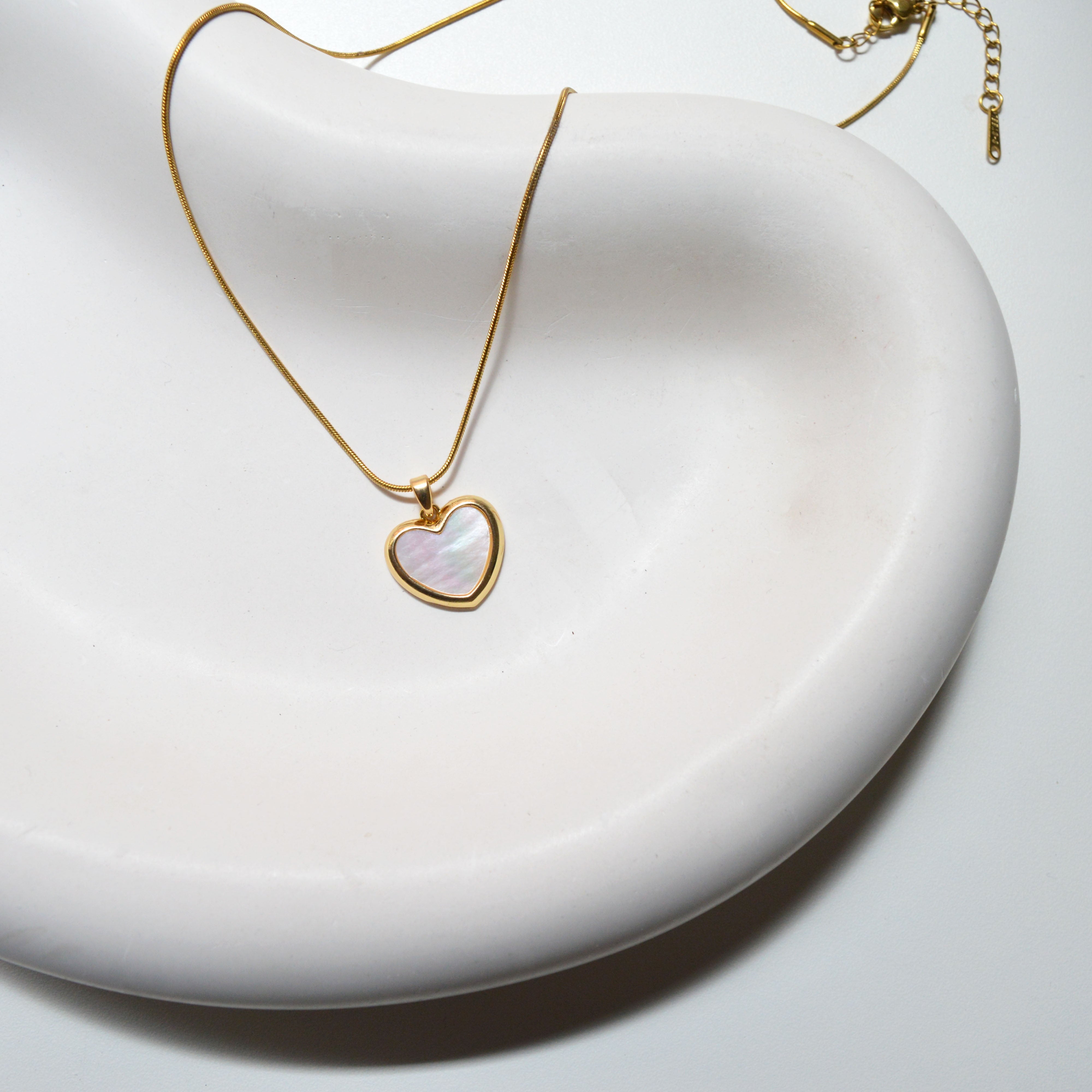 Close-up view of the polished heart frame and the iridescent Mother of Pearl detail on Minimalist Heart Pendant