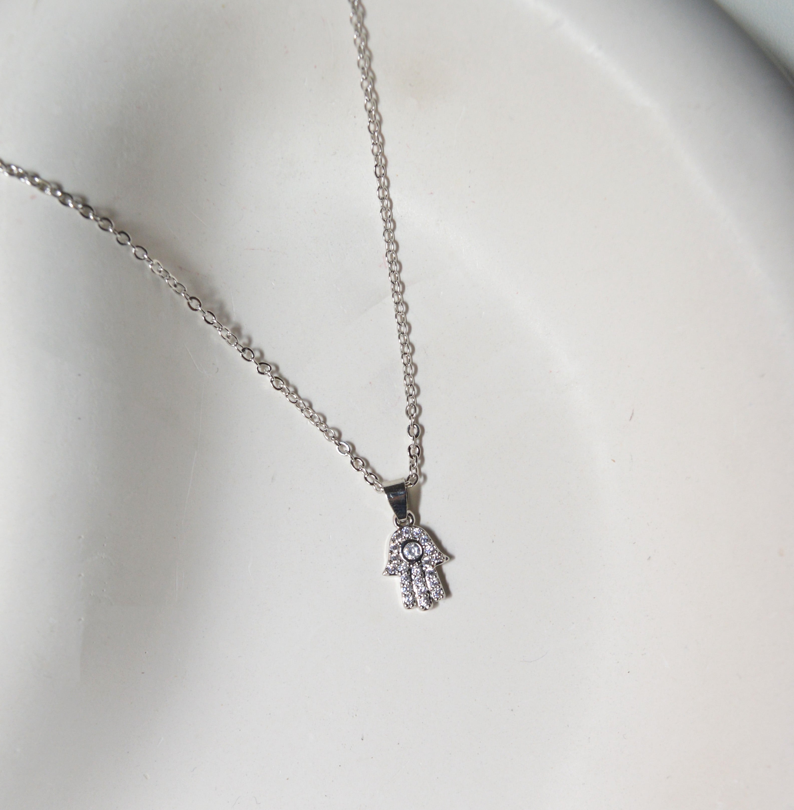Close-up view of the fine stone detailing and the high-polish texture of the Silver Hamsa Hand