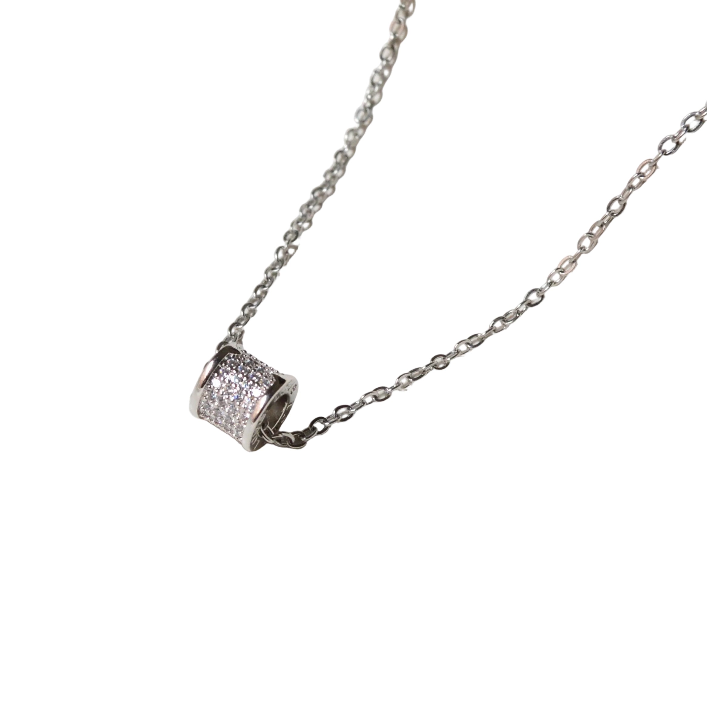 Close-up view of the dense, sparkling stone setting and the polished metal end-caps on Stellar Barrel Pendant