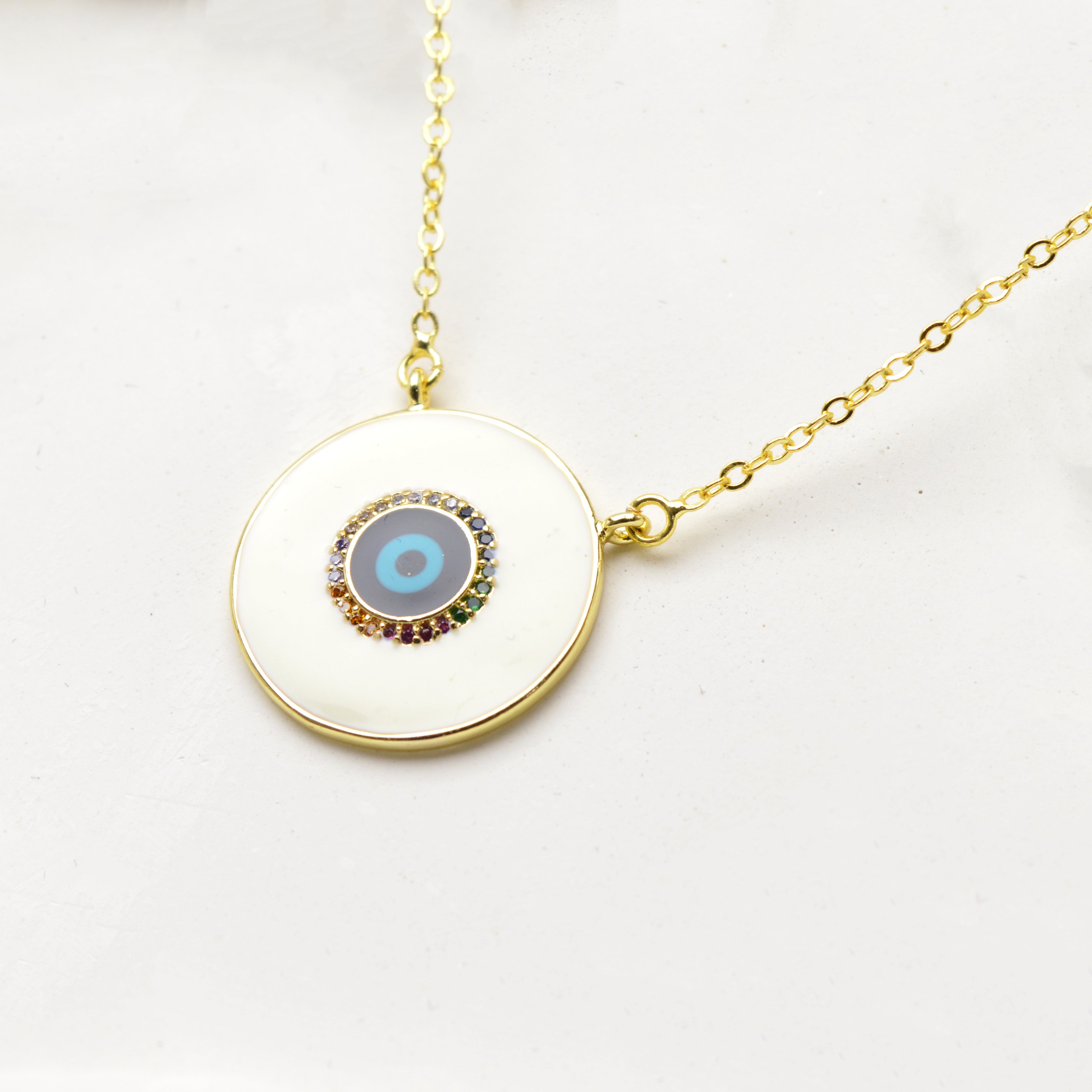 Close-up of model wearing gold tone evil eye pendant