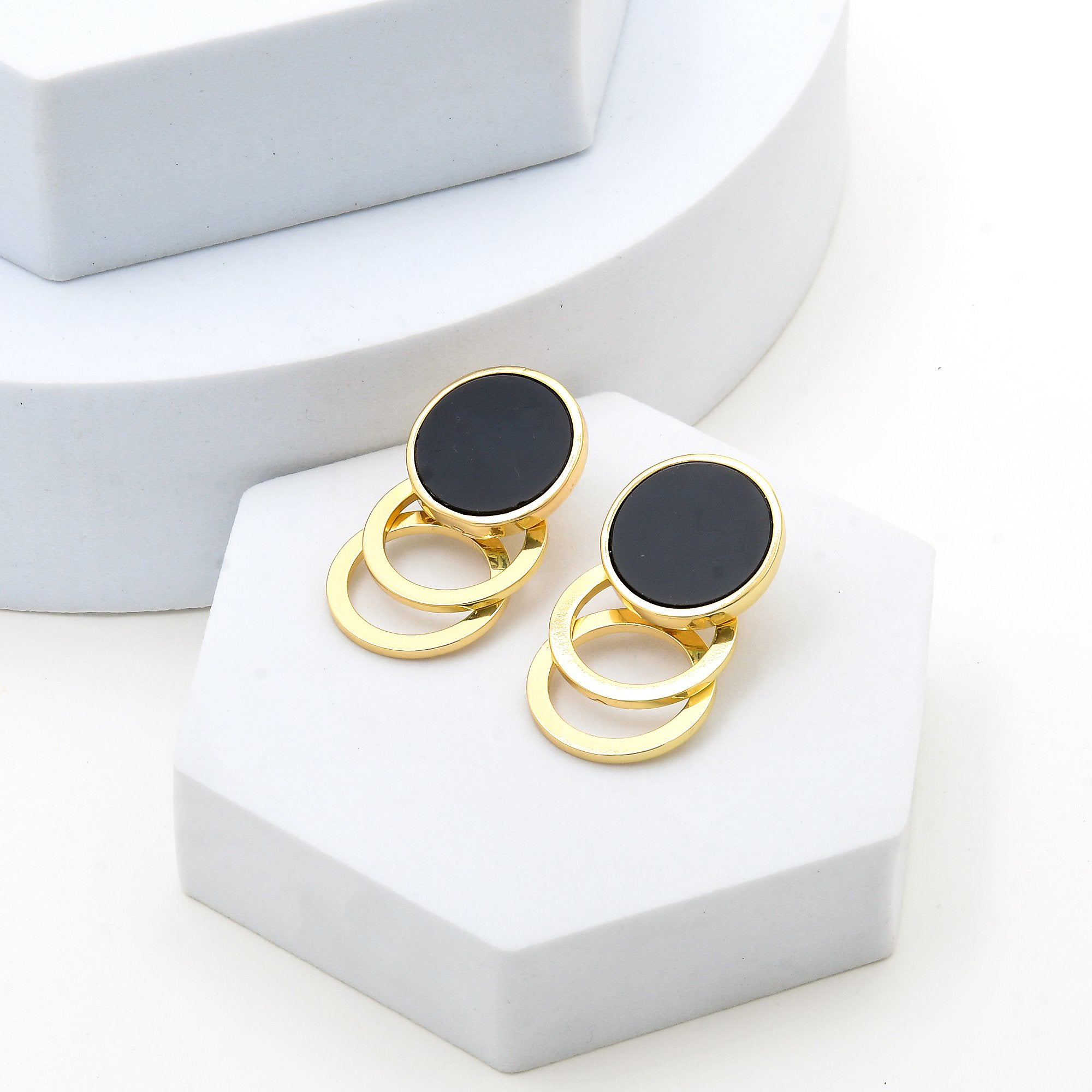 Pair of anti tarnish black and gold geometric statement earrings displayed on a clean white background