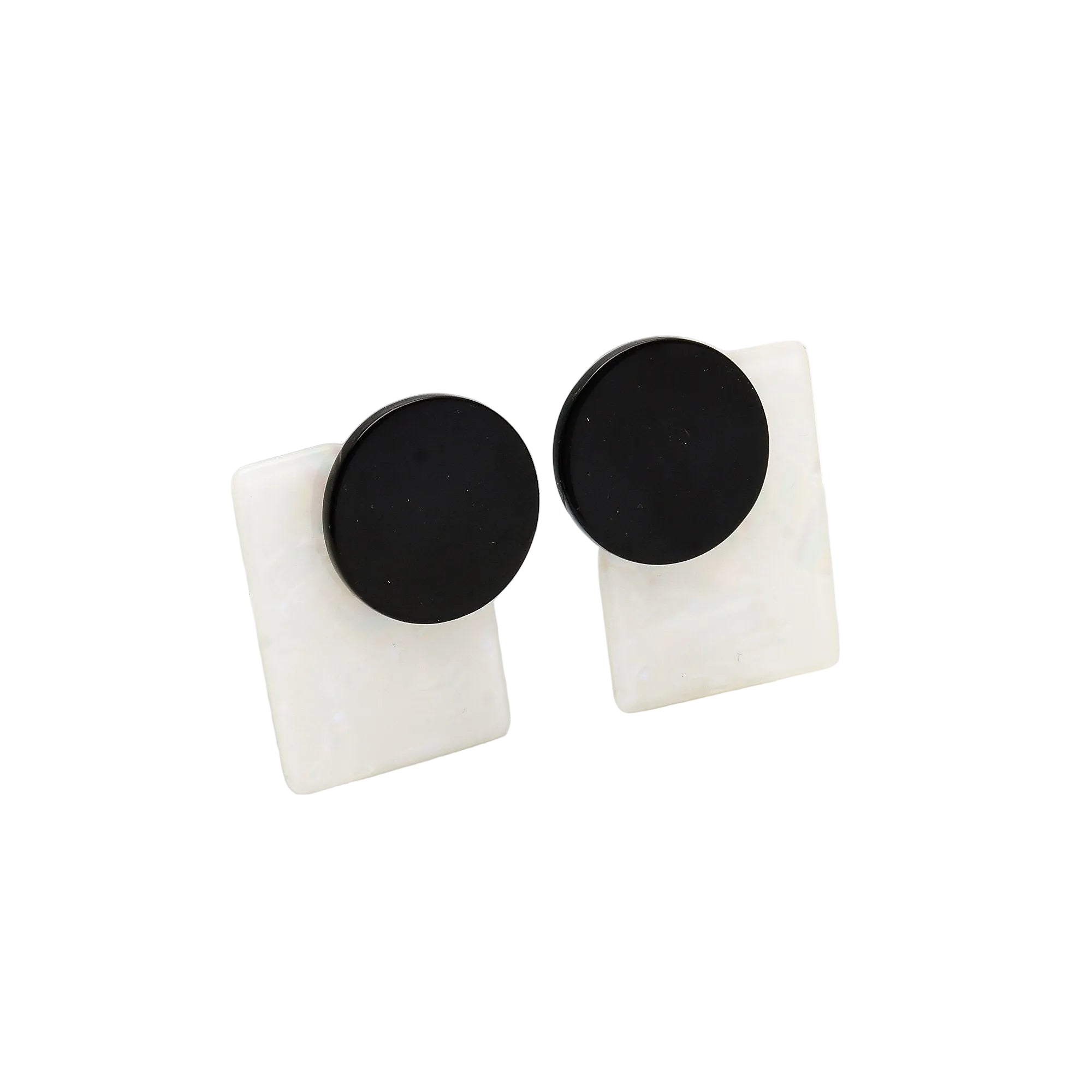 Onyx Aura geometric studs with black resin circular elements and iridescent white rectangular backing on display blocks