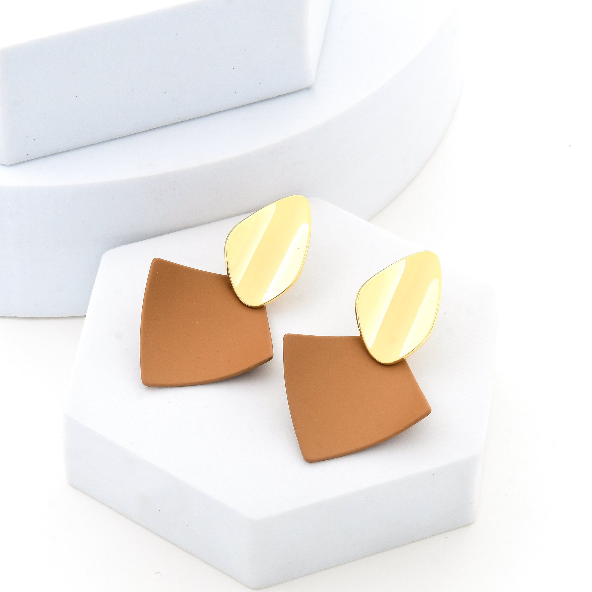 Pair of brown and gold abstract earrings showing the contrast between polished metal and matte resin