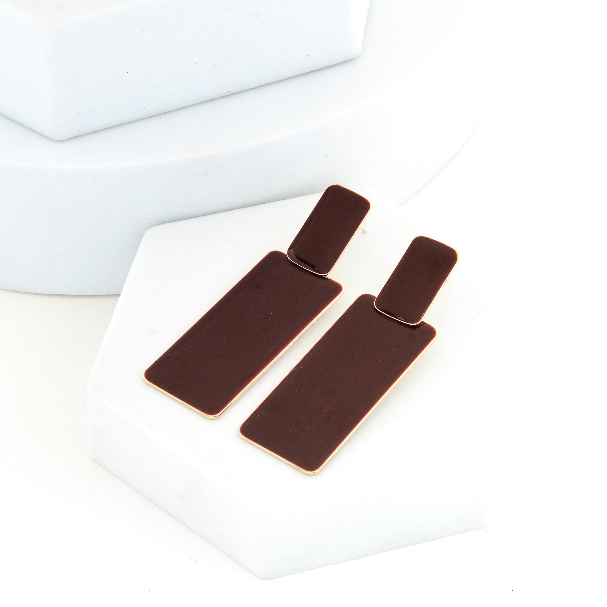 Pair of brown enamel rectangular statement earrings showing the contrast between the front enamel and gold tone back