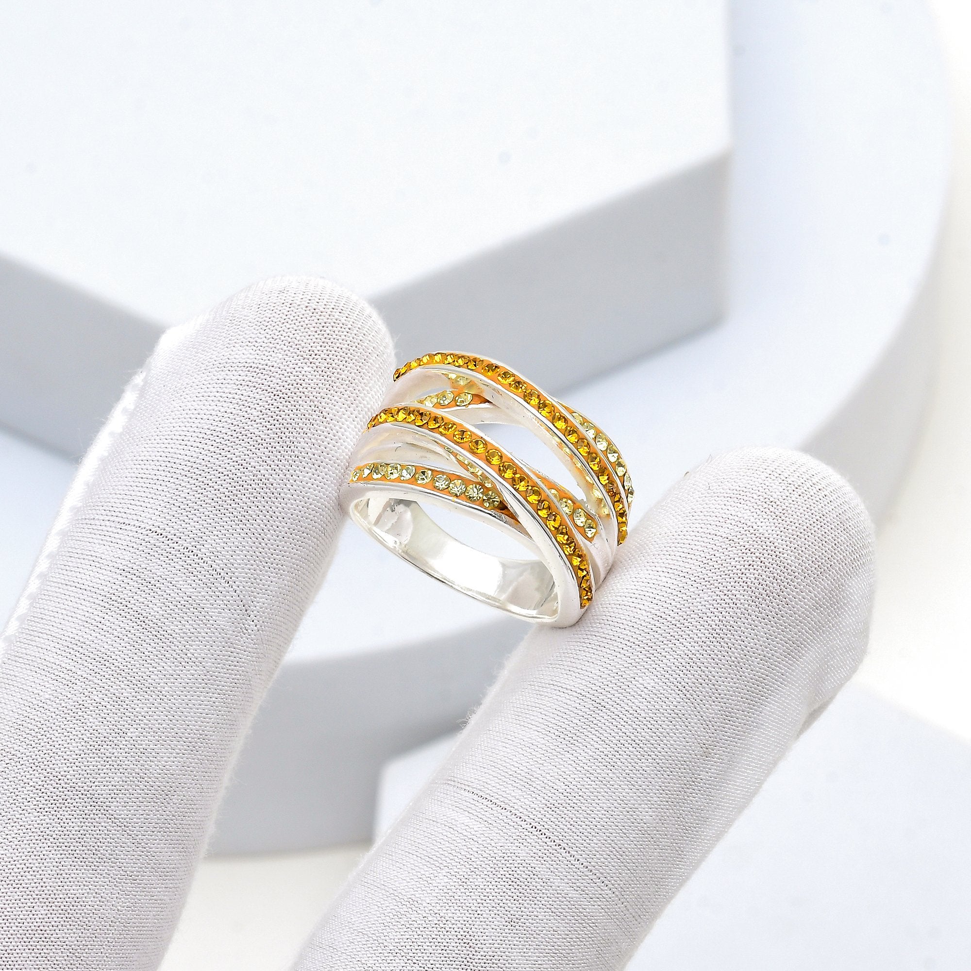 Profile shot of the Signature Citrine Crossover ring highlighting the smooth, high-polish silver-tone frame and rhythmic crisscross design