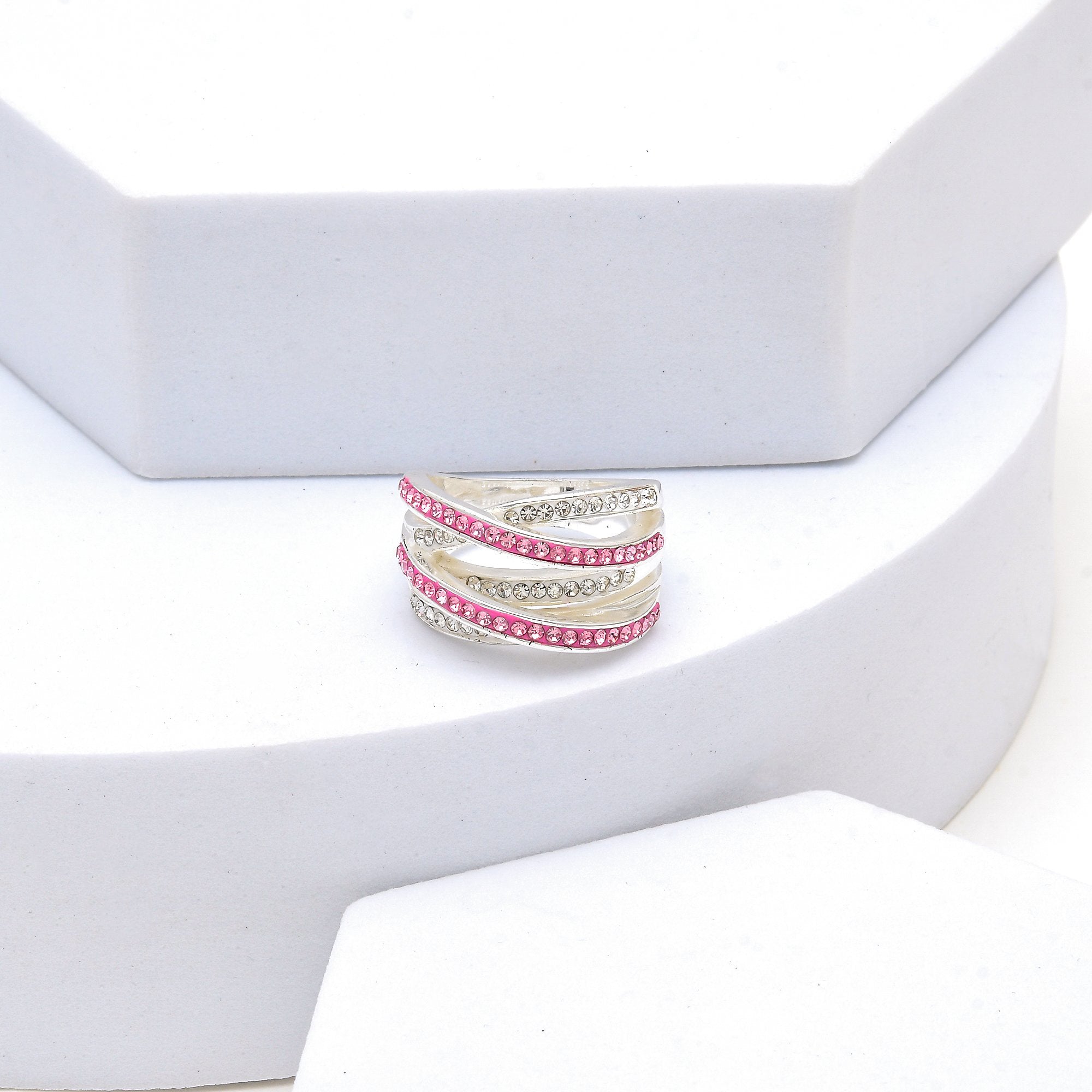 Hand holding the Signature Pink Crossover ring to capture the premium weight and reflective luster of the silver-plated finish