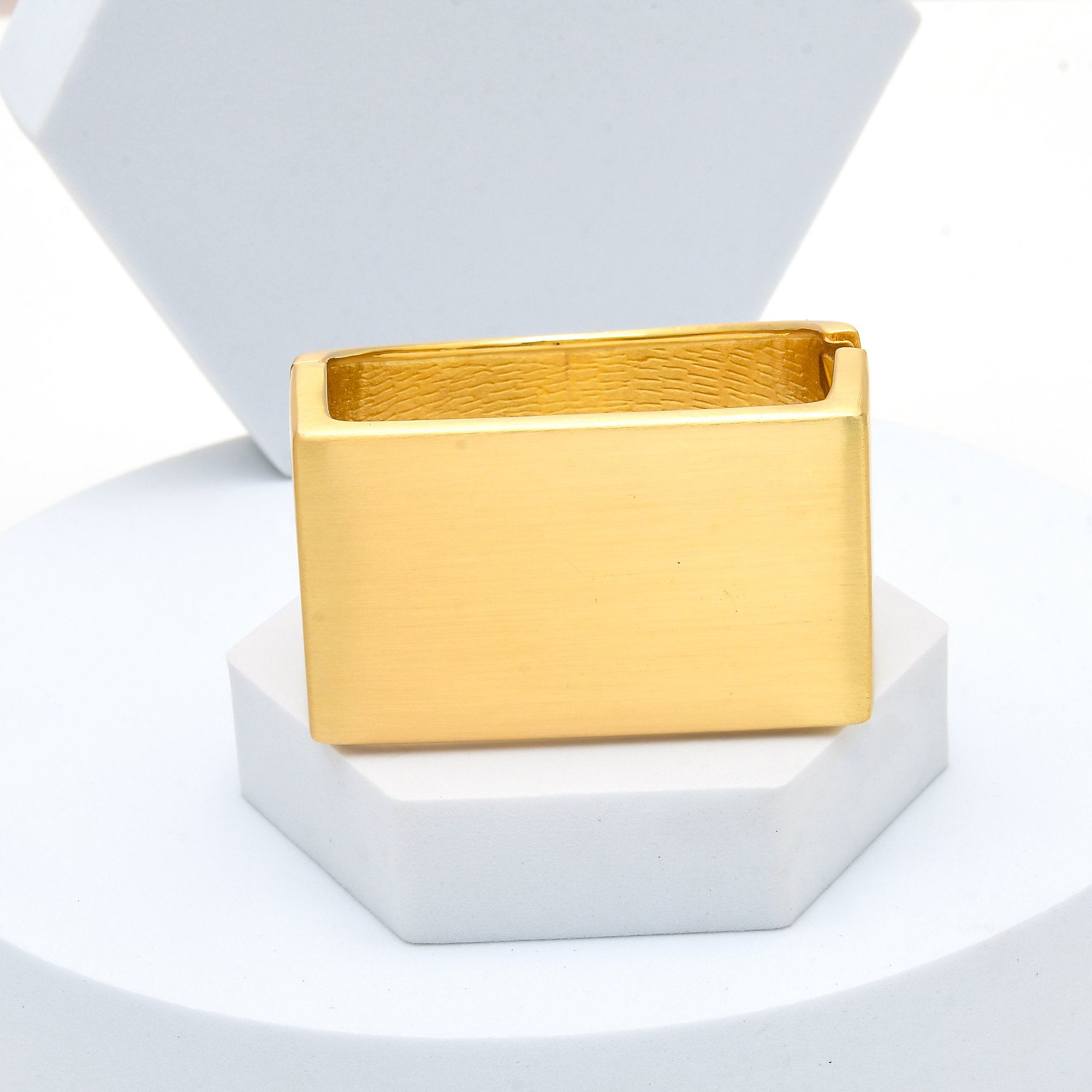 Profile shot of the Signature Architectural cuff highlighting the clean, minimalist geometry and matte gold-tone finish