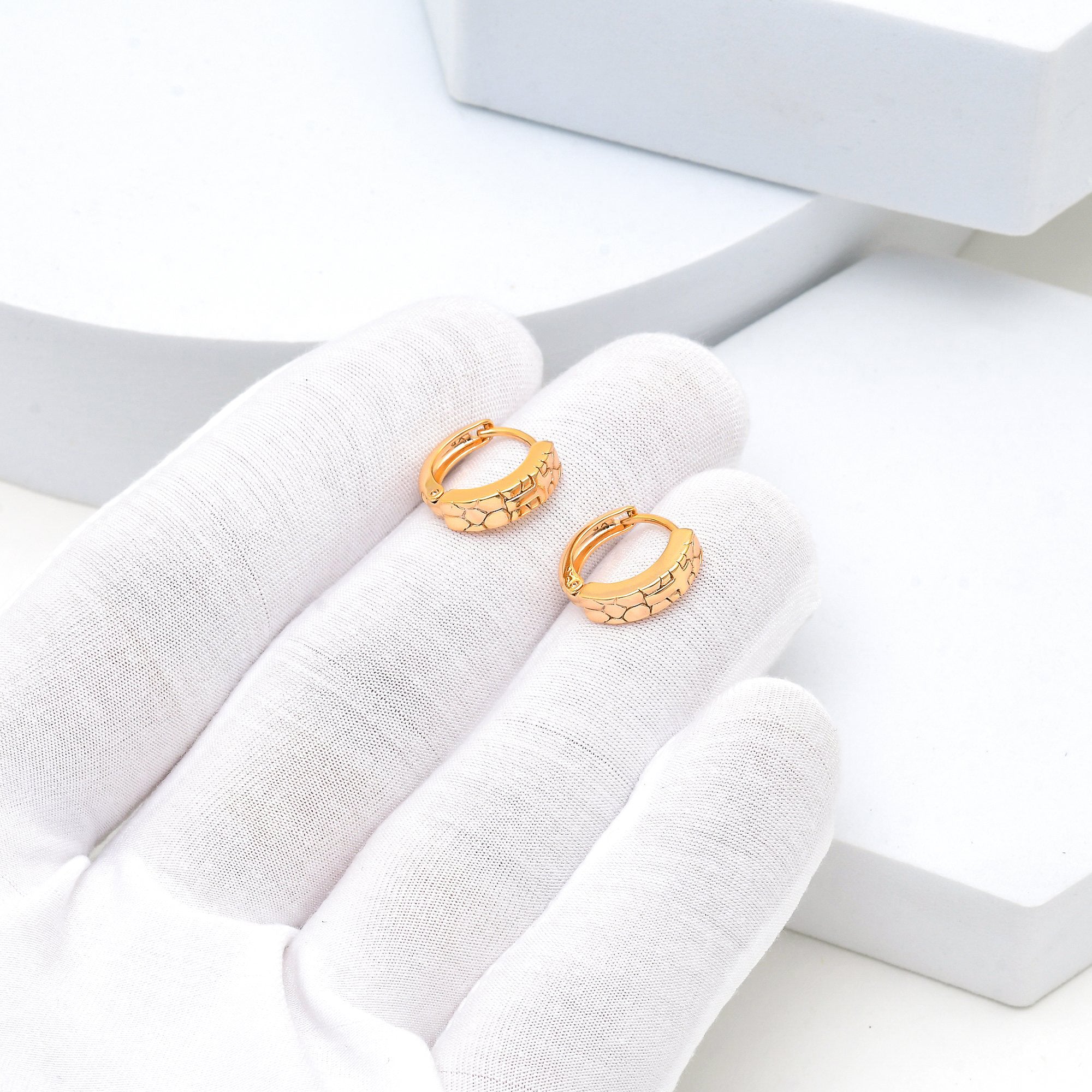 Close-up of minimal cross hoops designed for daily styling