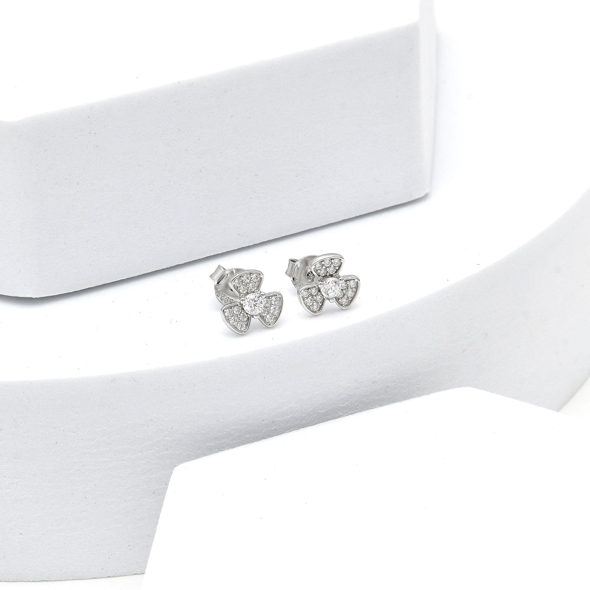 Elegant bow-shaped sterling silver stud earrings with sparkling stones