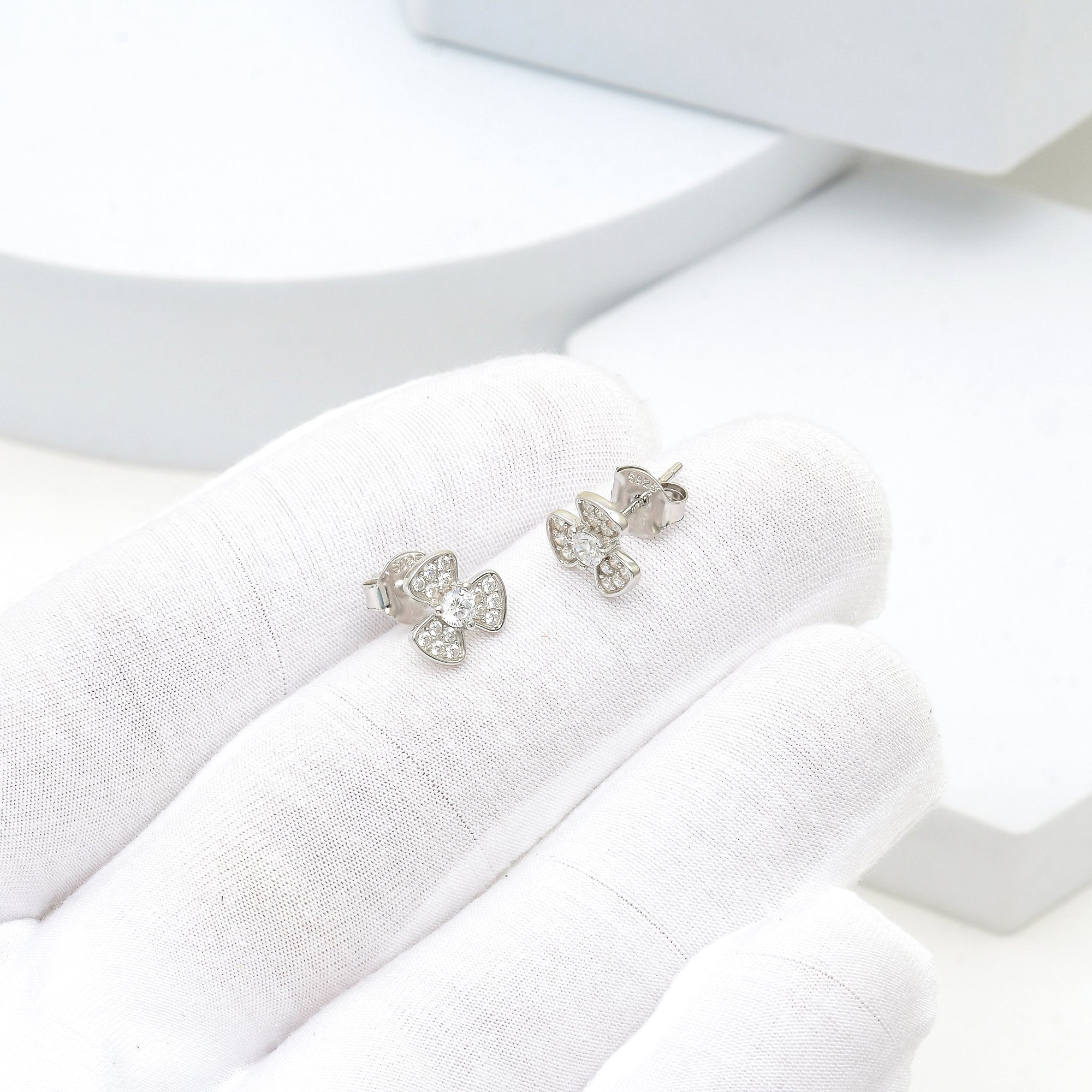 Model wearing 925 sterling silver bow stud earrings