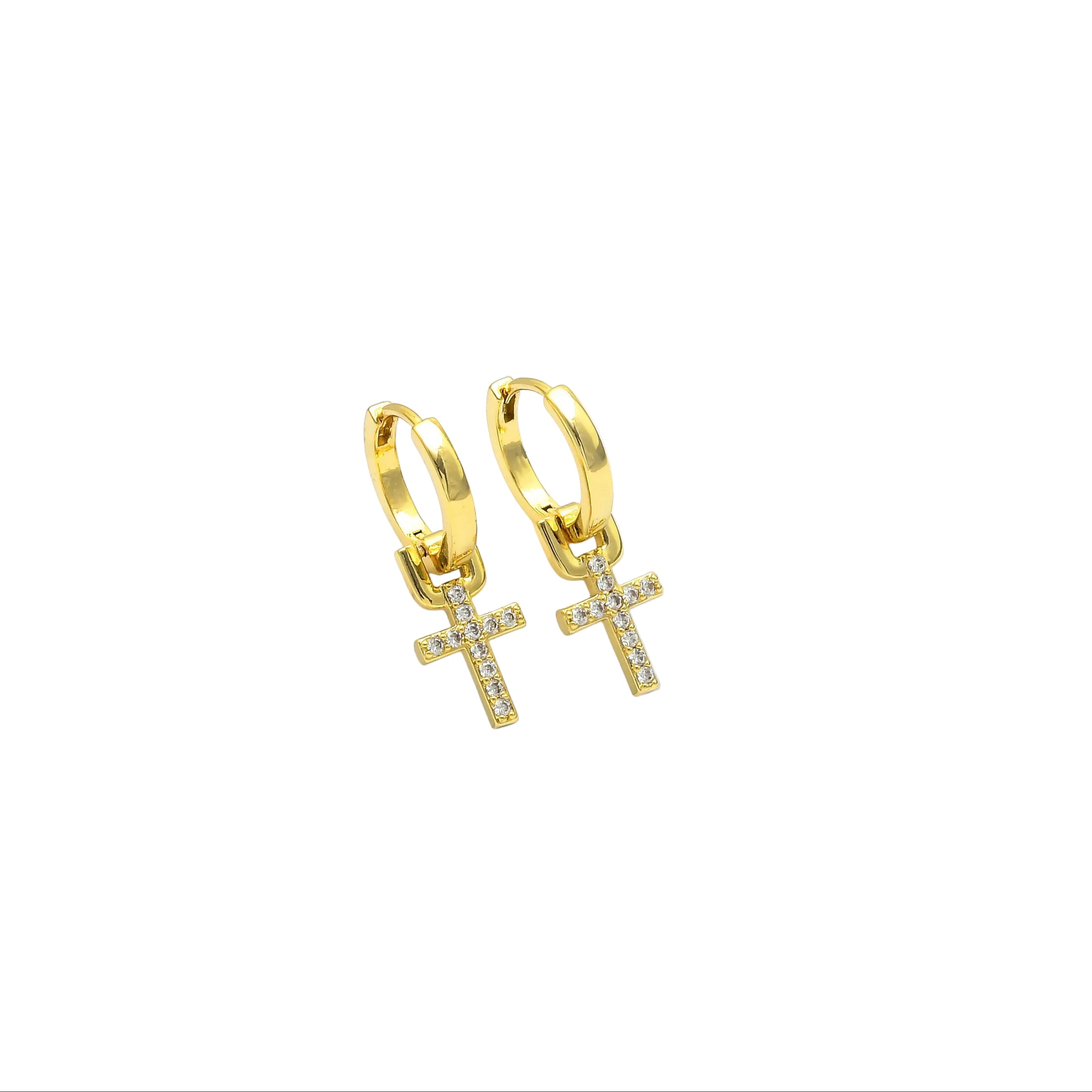 A pair of gold huggie hoop earrings with dangling cross charms, displayed on a white geometric stand by Civaro