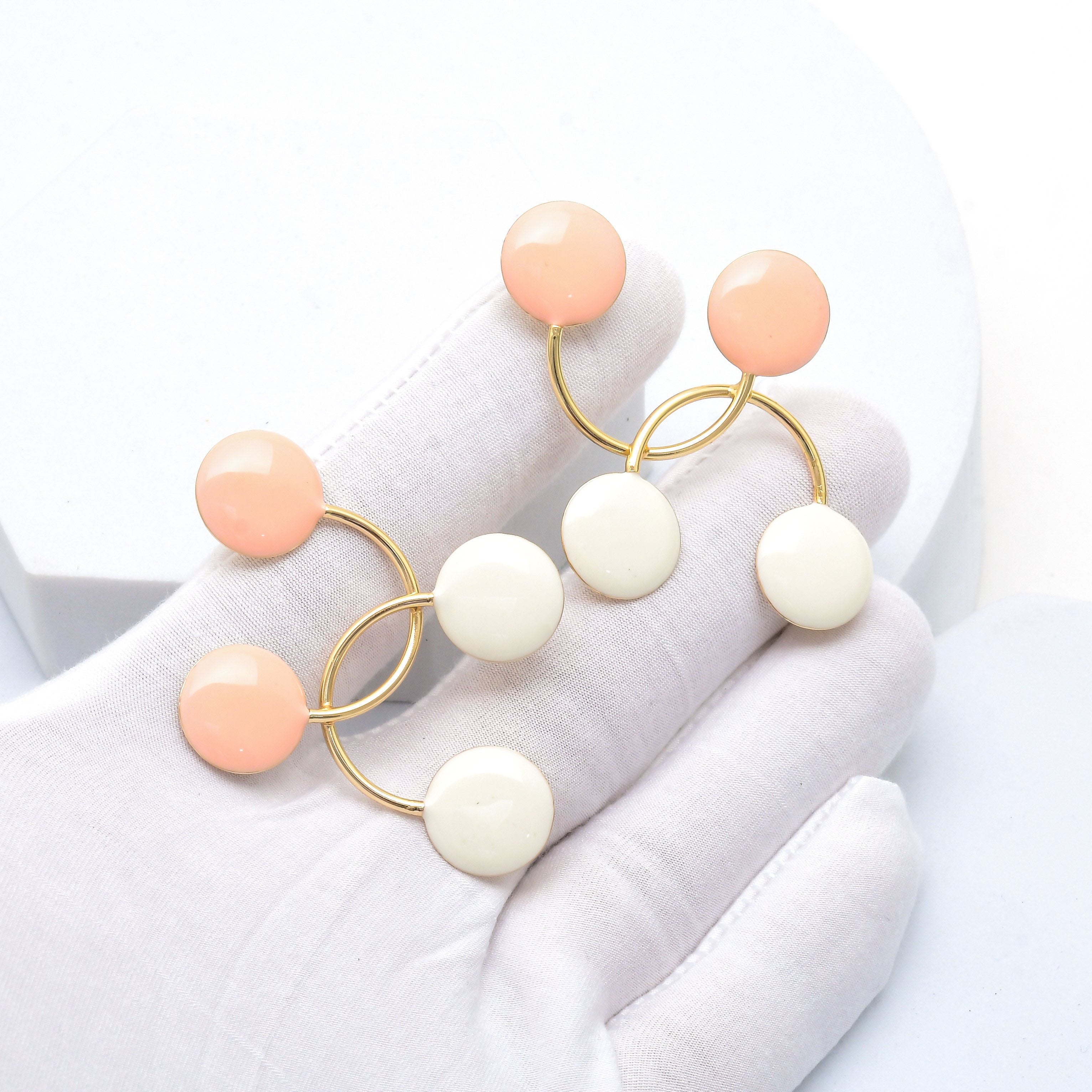 Gold tone stainless steel earrings featuring blush pink and white enamel accents for elegant everyday styling by Civaro.
