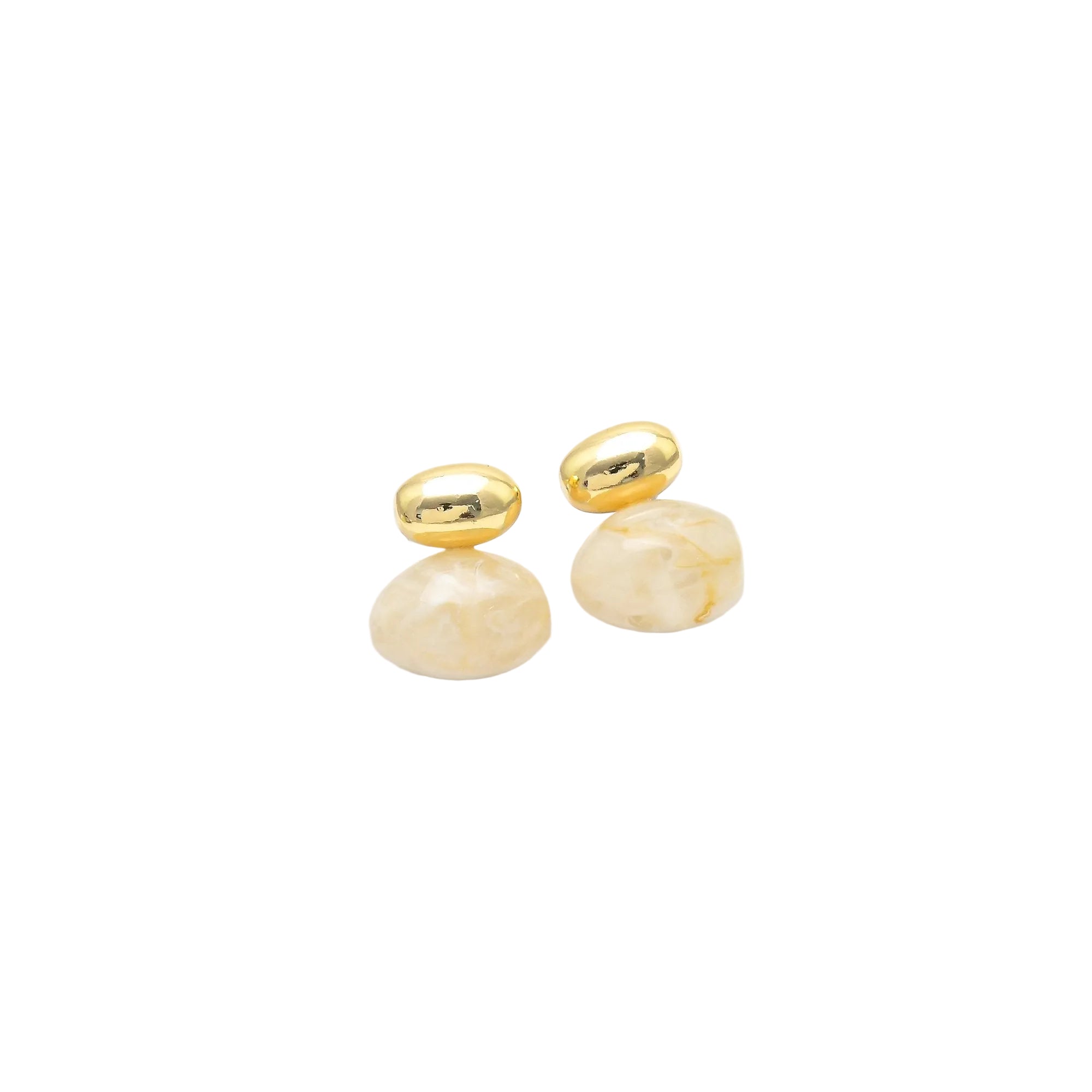 A pair of gold stud earrings with smooth, polished oval posts and faceted, rounded cream-colored stone drops, displayed on a white geometric stand against a white background by Civaro