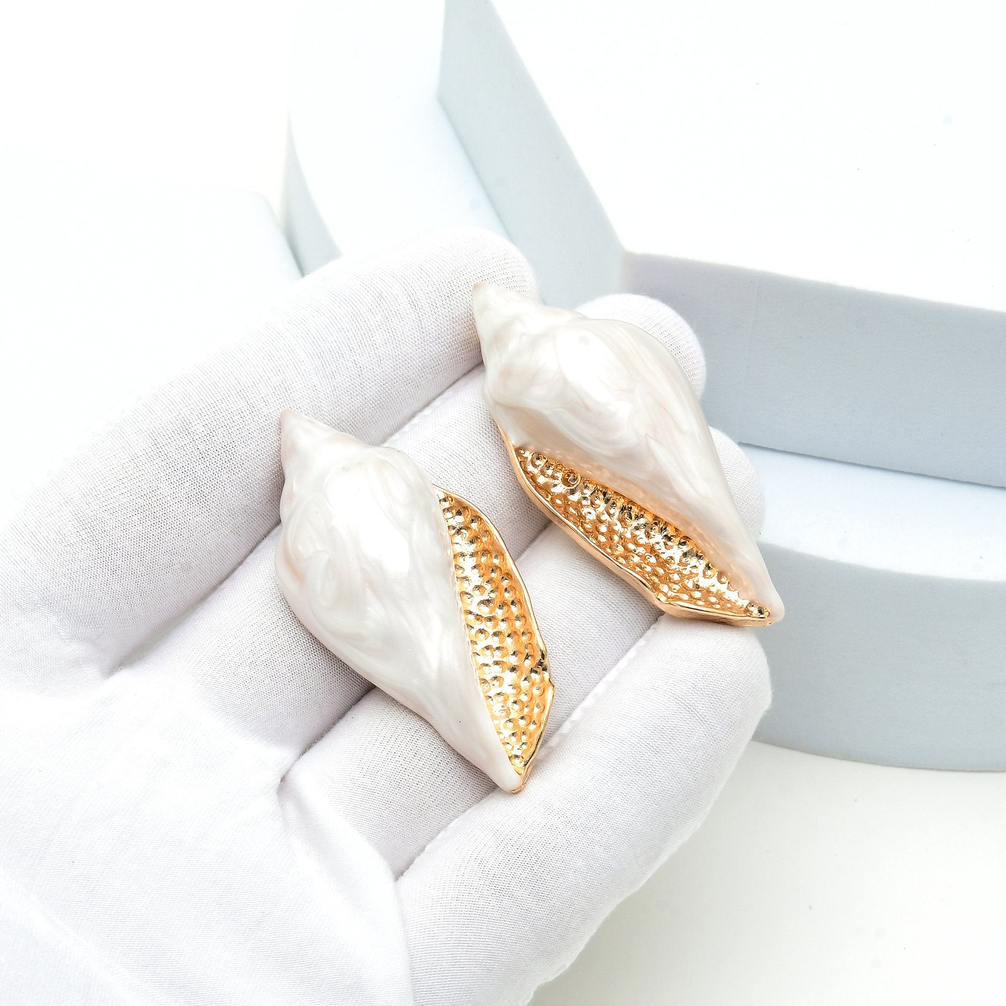 Coastal-inspired shell earrings with glossy pearl effect finish and gold accents, lightweight handcrafted statement jewelry for women.