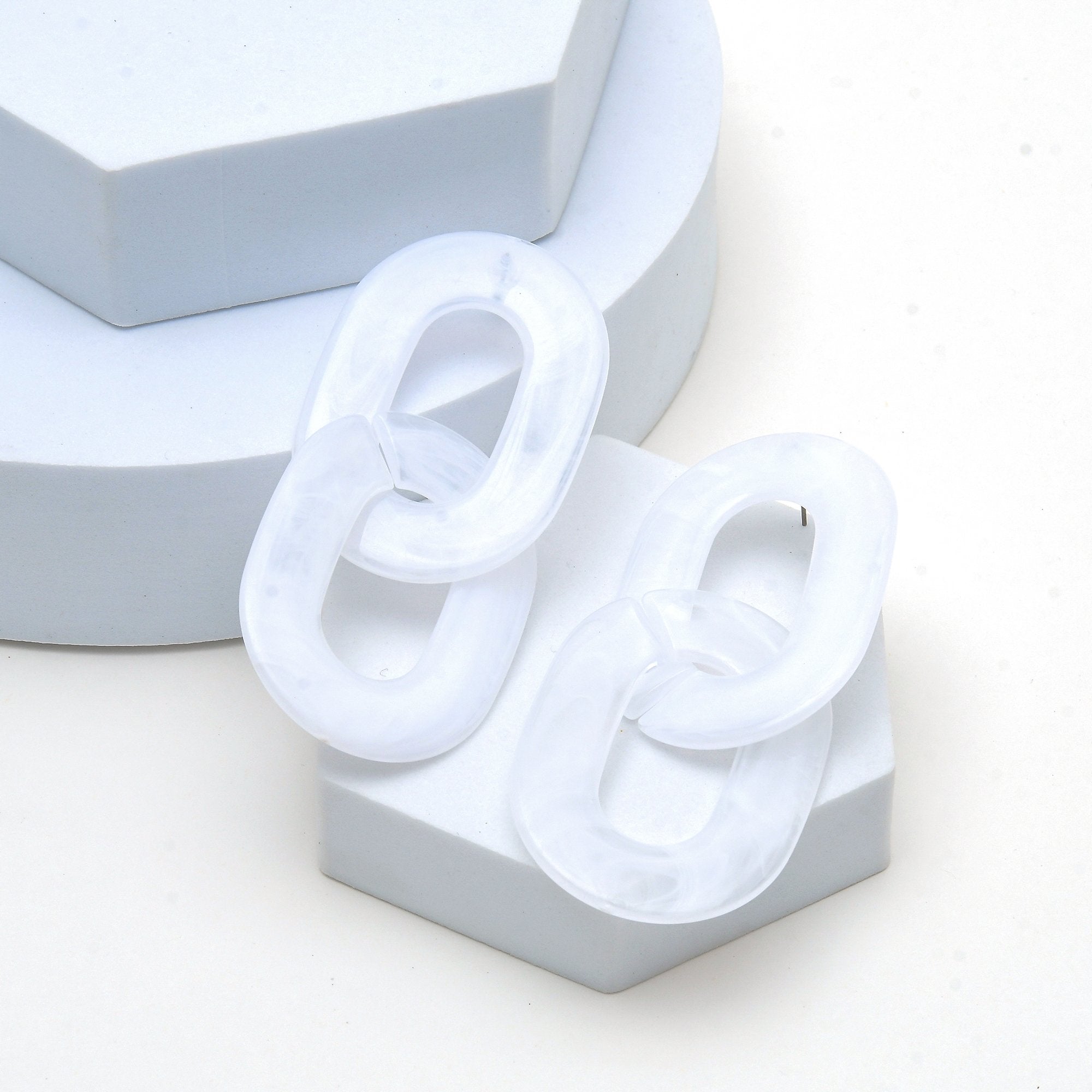 Modern acrylic chain-link earrings worn by a model, showcasing their bold yet lightweight contemporary design.