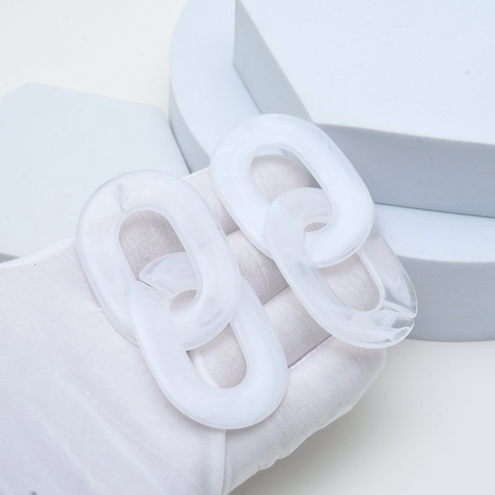 Oversized marbled acrylic earrings inspired by contemporary fashion with sculptural interlocking links.