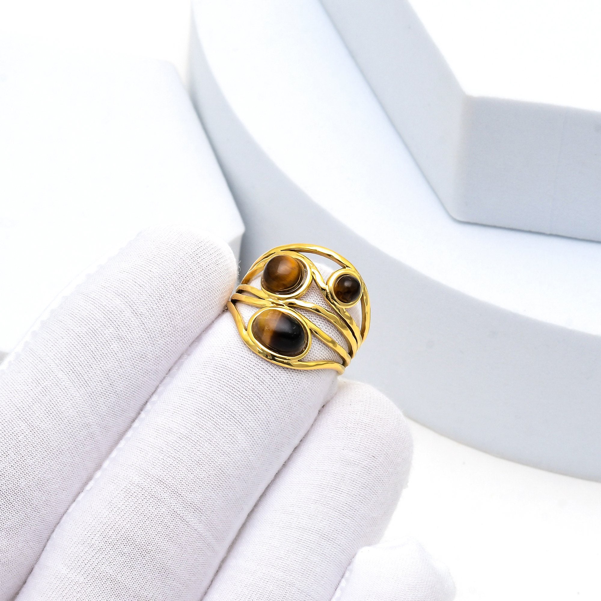     Modern stainless steel ring showcasing triple tiger eye stone accents.