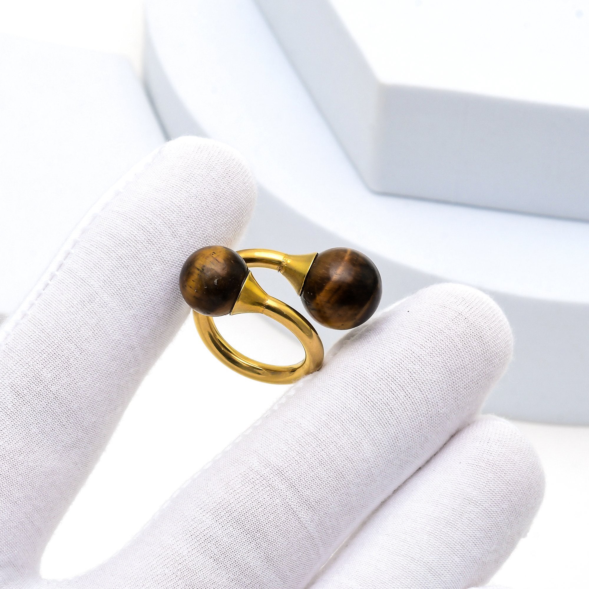 Modern stainless steel ring showcasing dual tiger eye stone spheres.
