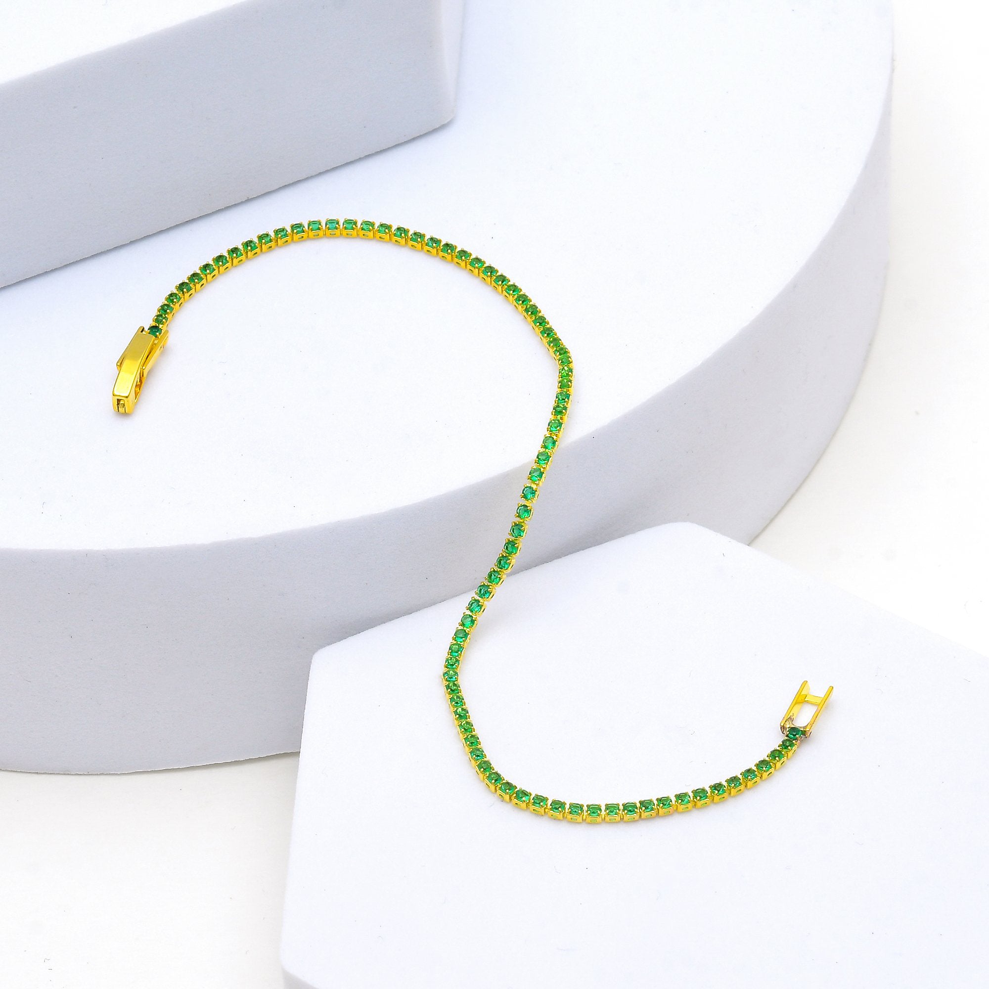     Gold stainless steel tennis bracelet with emerald green cubic zirconia.