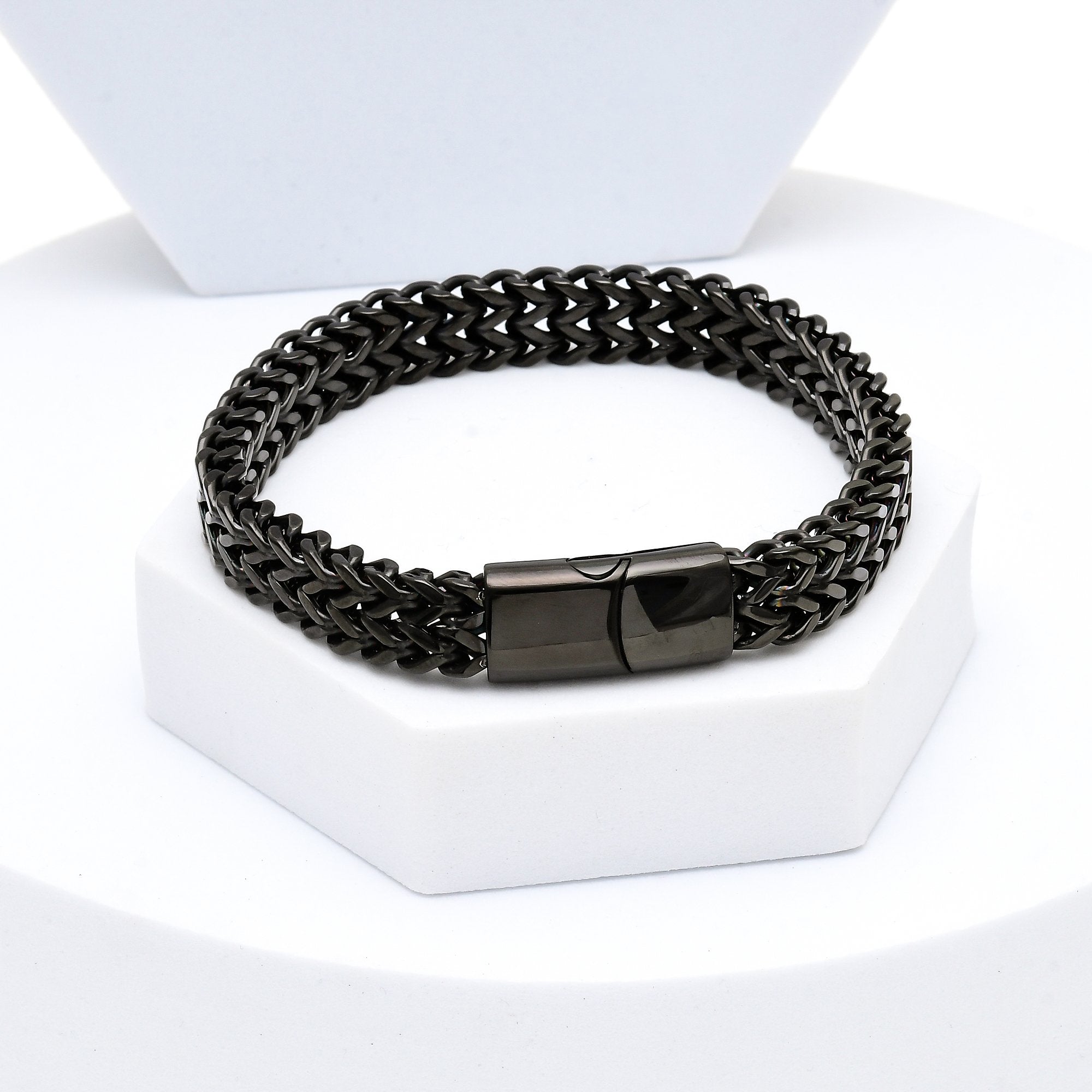 Black chain bracelet on a white stand with a white background