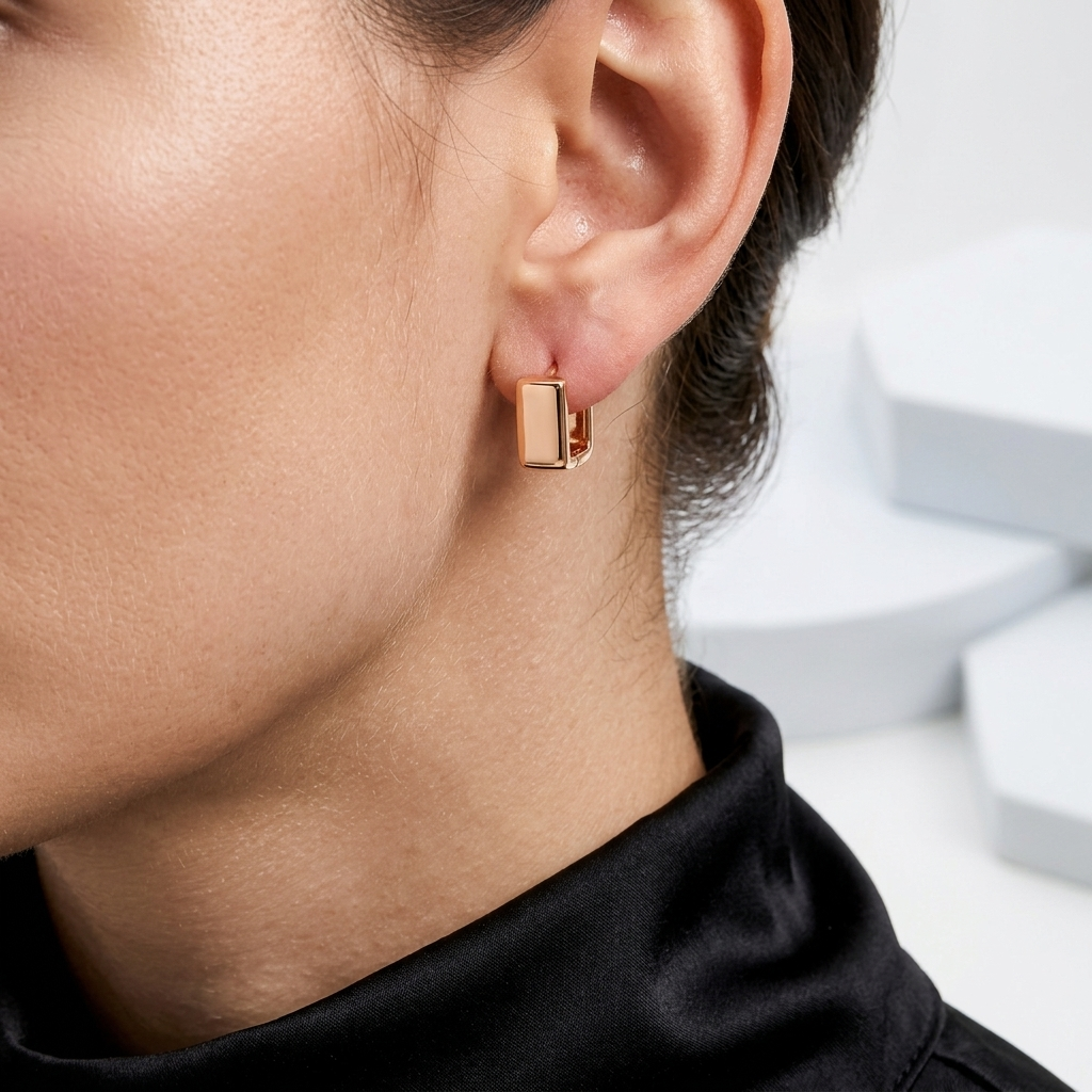 Close-up of model wearing stainless steel geometric huggie earrings