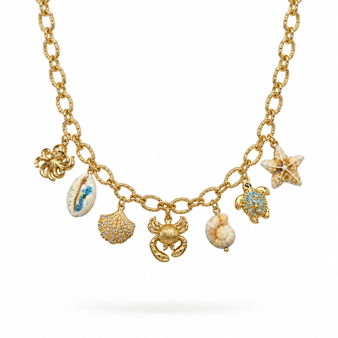 Gold-tone ocean charm necklace with seven sea-life charms including shells, crab, turtle, starfish and octopus by Civaro
A gold chain necklace featuring seven sea-themed charms, including a starfish, turtle, crab, shell, octopus, and seashell, displayed on a clean white background.