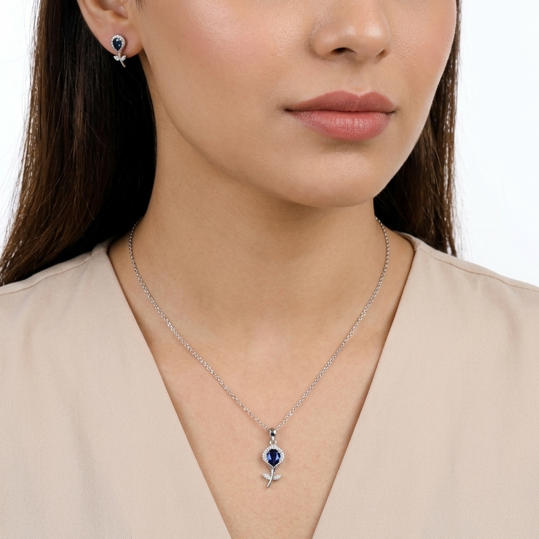 Model wearing 925 sterling silver flower pendant set with blue stone detailing