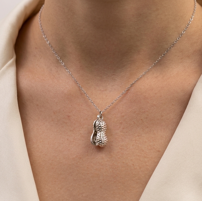 Model wearing Peanut Pearl Locket to showcase its organic shape and unique interactive scale against the neckline
