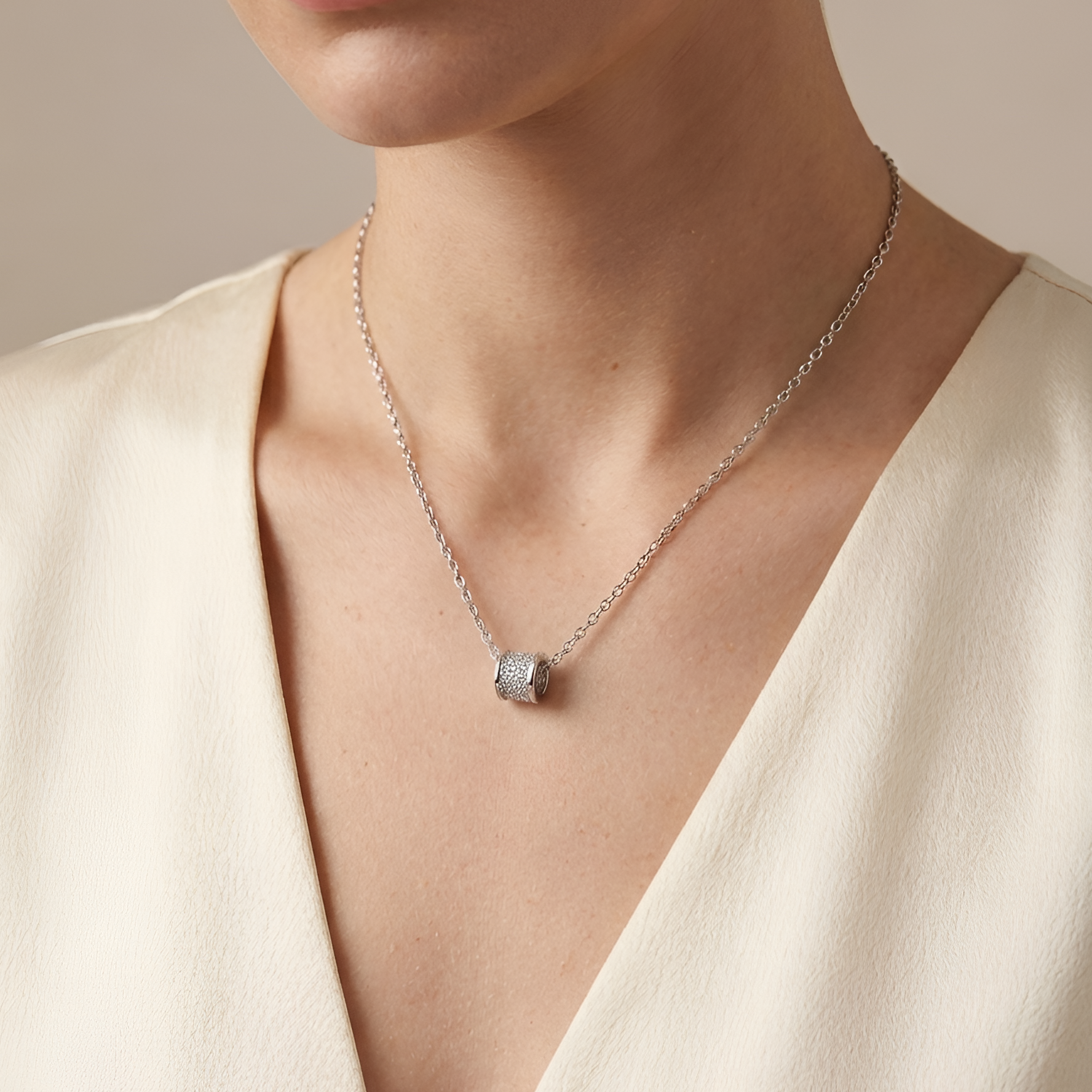 Model wearing Stellar Barrel Pendant to showcase its structured silhouette and radiant sparkle against the neckline