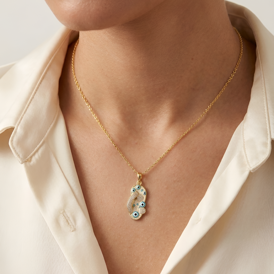 Model wearing The Amulet pendant on a gold-tone chain to show its scale and refined finish against the skin