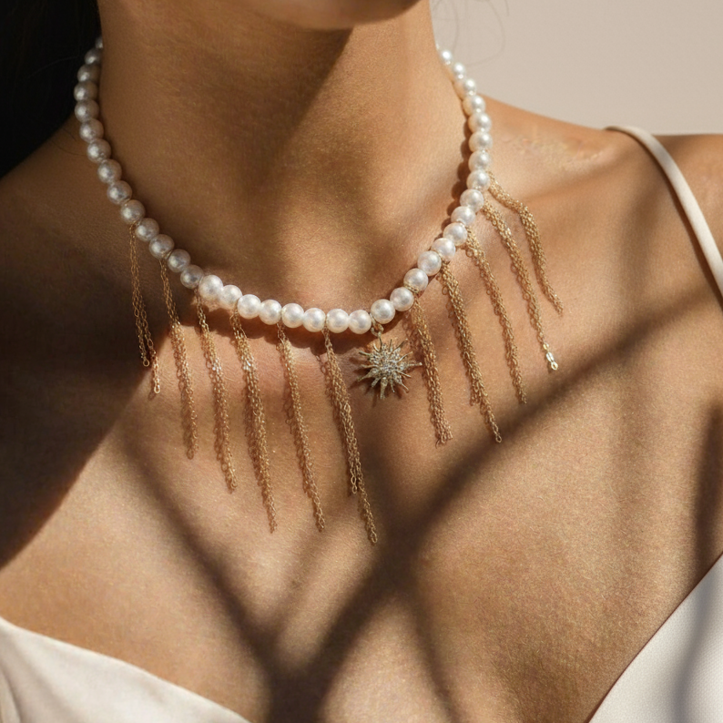 Model wearing The Celestial Fringe necklace to showcase the graceful drape of the pearls and gold-tone chains against the neckline