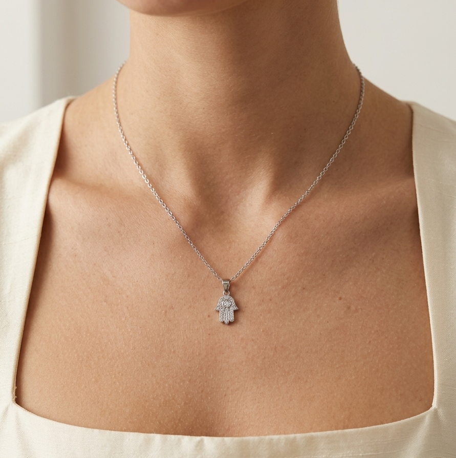 Model wearing the Silver Hamsa Hand to showcase its elegant scale and brilliance against the neckline