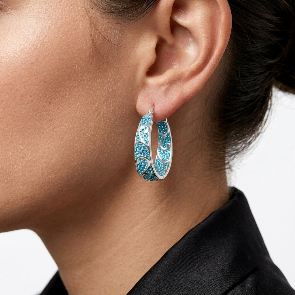 Model wearing the handcrafted Signature Teal Swirl hoops to demonstrate their sculptural scale and vibrant color