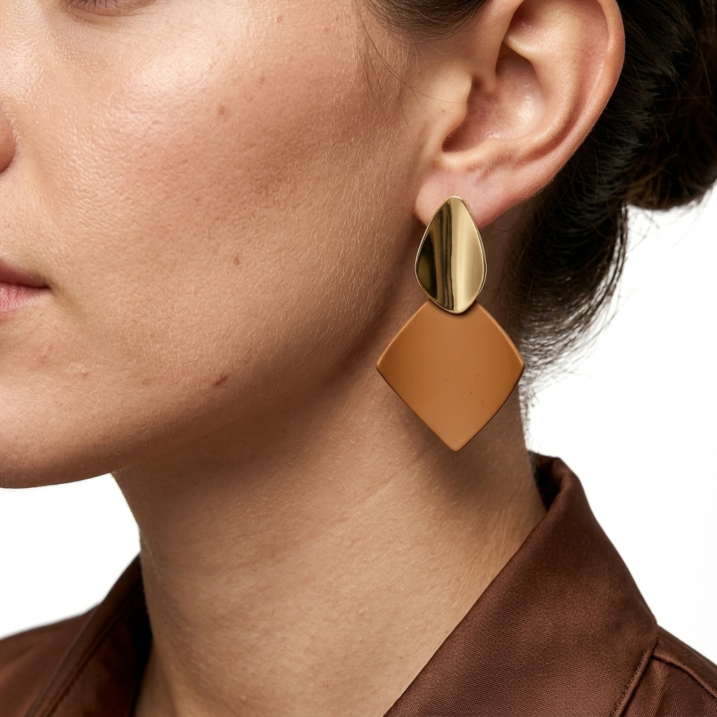 Model wearing the tan and gold Terra geometric studs to demonstrate their modern sculptural scale