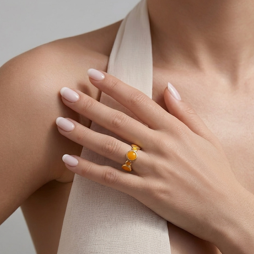 Model wearing the orange Solis enamel adjustable ring to demonstrate its scale and open back contouring