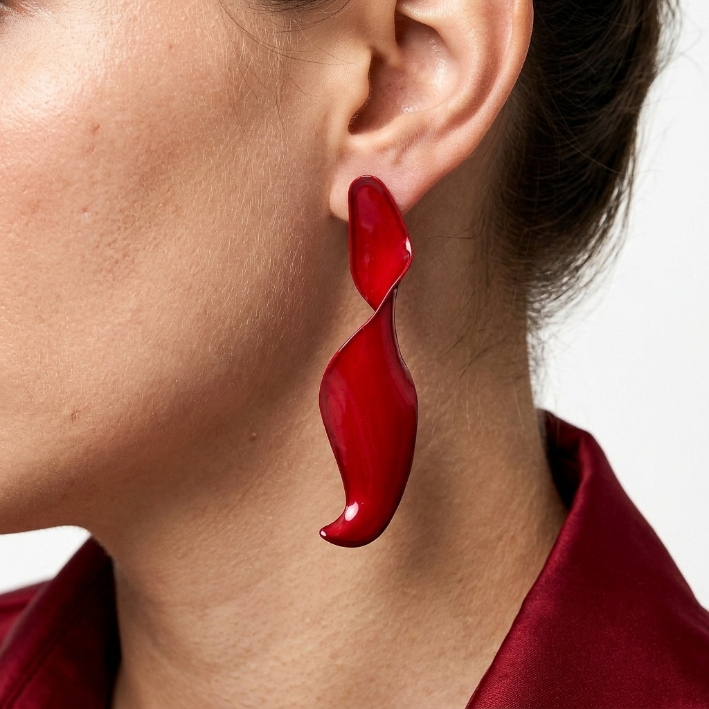 Model wearing a red Crimson Fluidity sculptural stud earring showcasing its scale