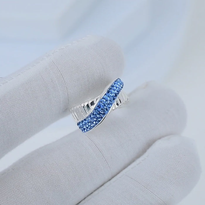Video showcasing the intricate handcrafted details, fluid movement of the crisscross design, and the rich, light-catching depth of the Signature Azure Crossover ring