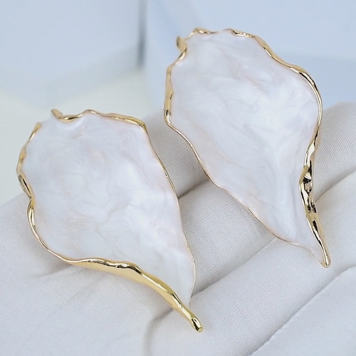     Artistic white marbled acrylic earrings inspired by natural forms and handcrafted luxury jewelry.