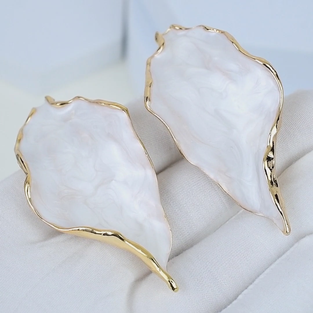     Artistic white marbled acrylic earrings inspired by natural forms and handcrafted luxury jewelry.