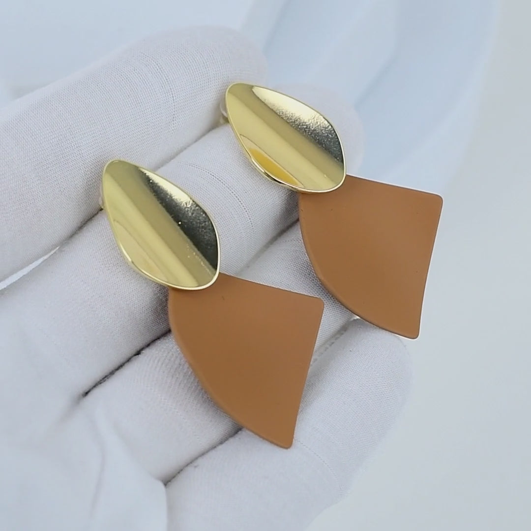 deo showing the light reflecting off the polished gold surface and the clean lines of the Terra geometric earrings