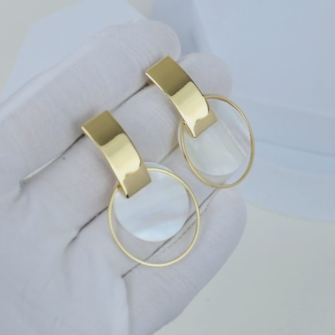 Close up of gold geometric shell earrings showing polished brass finish and iridescent shell centerpiece by Civaro