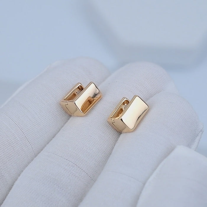 Video showcasing Nova Geometric Huggie Earrings with polished rose gold tone finish and geometric design