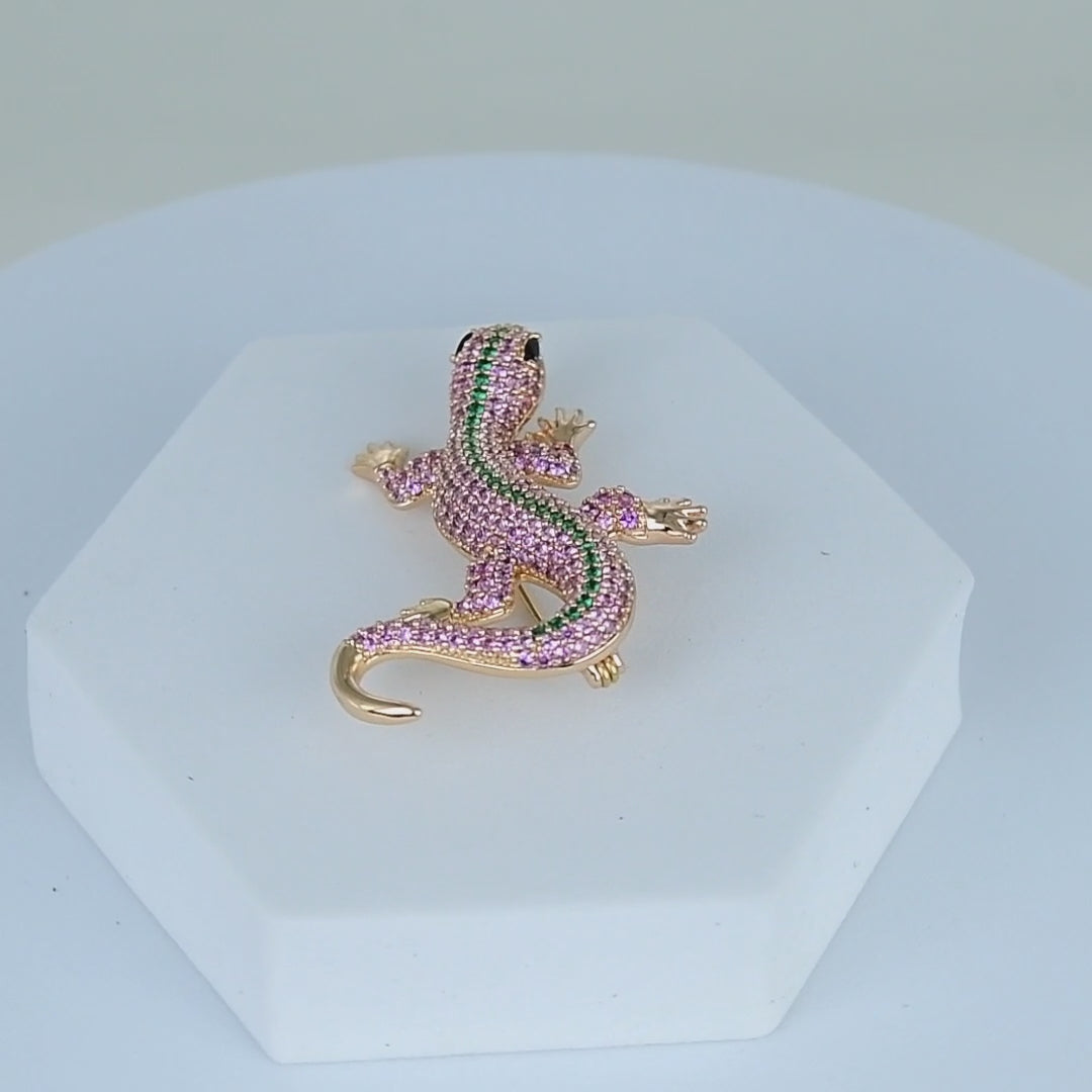     Designer-inspired crystal lizard pin displayed on a white pedestal background.